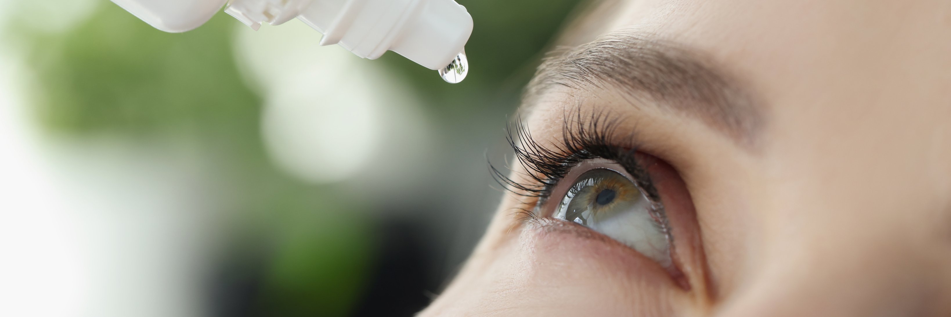 Woman Drips Eye Drops into Eye for Allergies Closeup